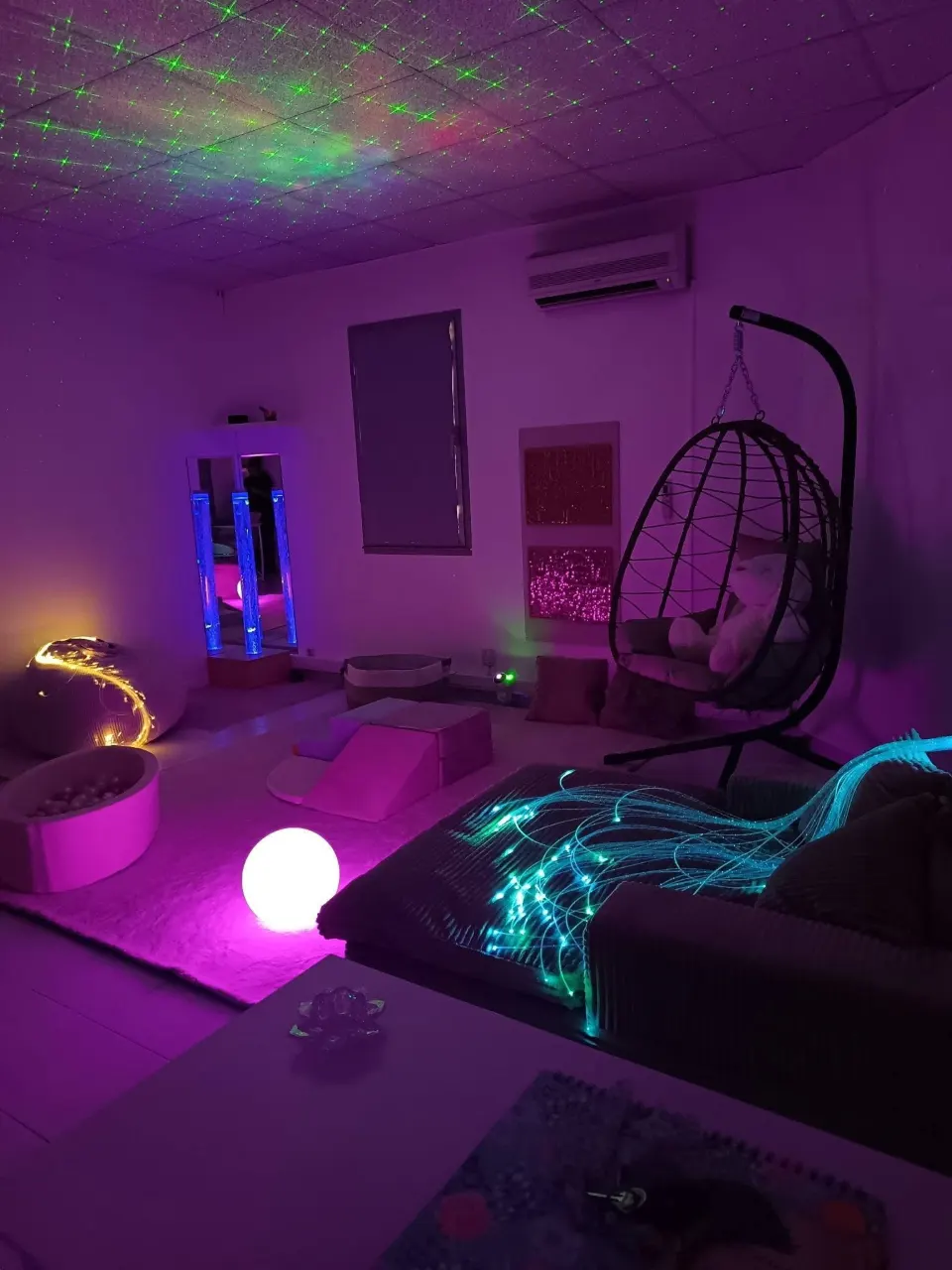 Notre salle : colonne à bulles, fauteuil suspendu, piscine à balles et fibres optiques, dans une lumière douce